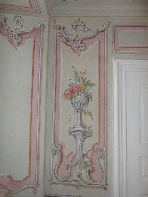 Týž panel po restaurování: váza s pestrými květy na podstavci, růžový rám a šedé rokajové ornamenty