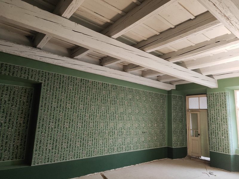 Zelené šablonové malby stěn pod bílým trámovým stropem, Příbor po restaurování